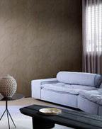 Shards wallpaper by Arte in Brown behind a lilac sofa and a black coffee table