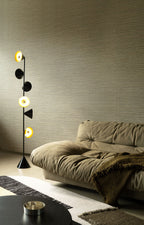 Sombra wallpaper by Arte in Beige – Camouflage behind an olive sofa and a floor lamp