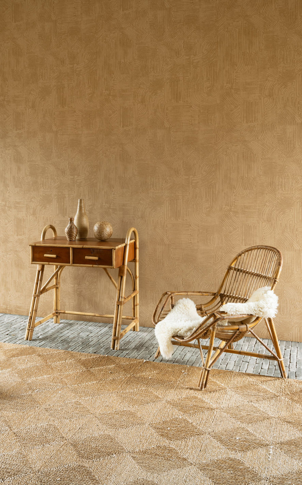 Tamba wallpaper by Arte in Orange behind a cane desk and a rattan chair