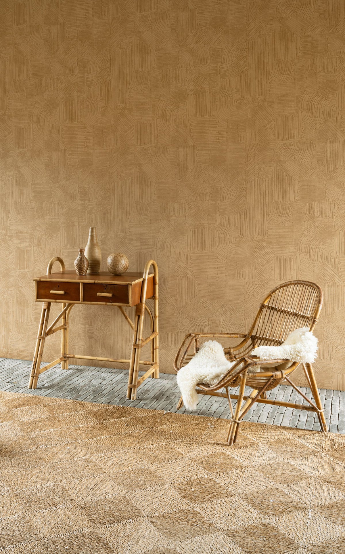Tamba wallpaper by Arte in Orange behind a cane desk and a rattan chair