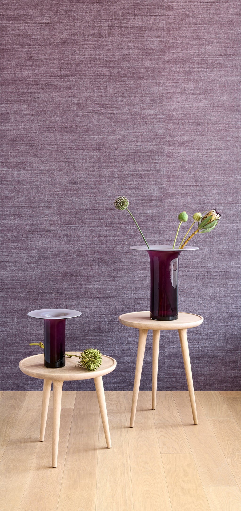 Canvas wallpaper by Arte in Purple behind two vases on small timber tables