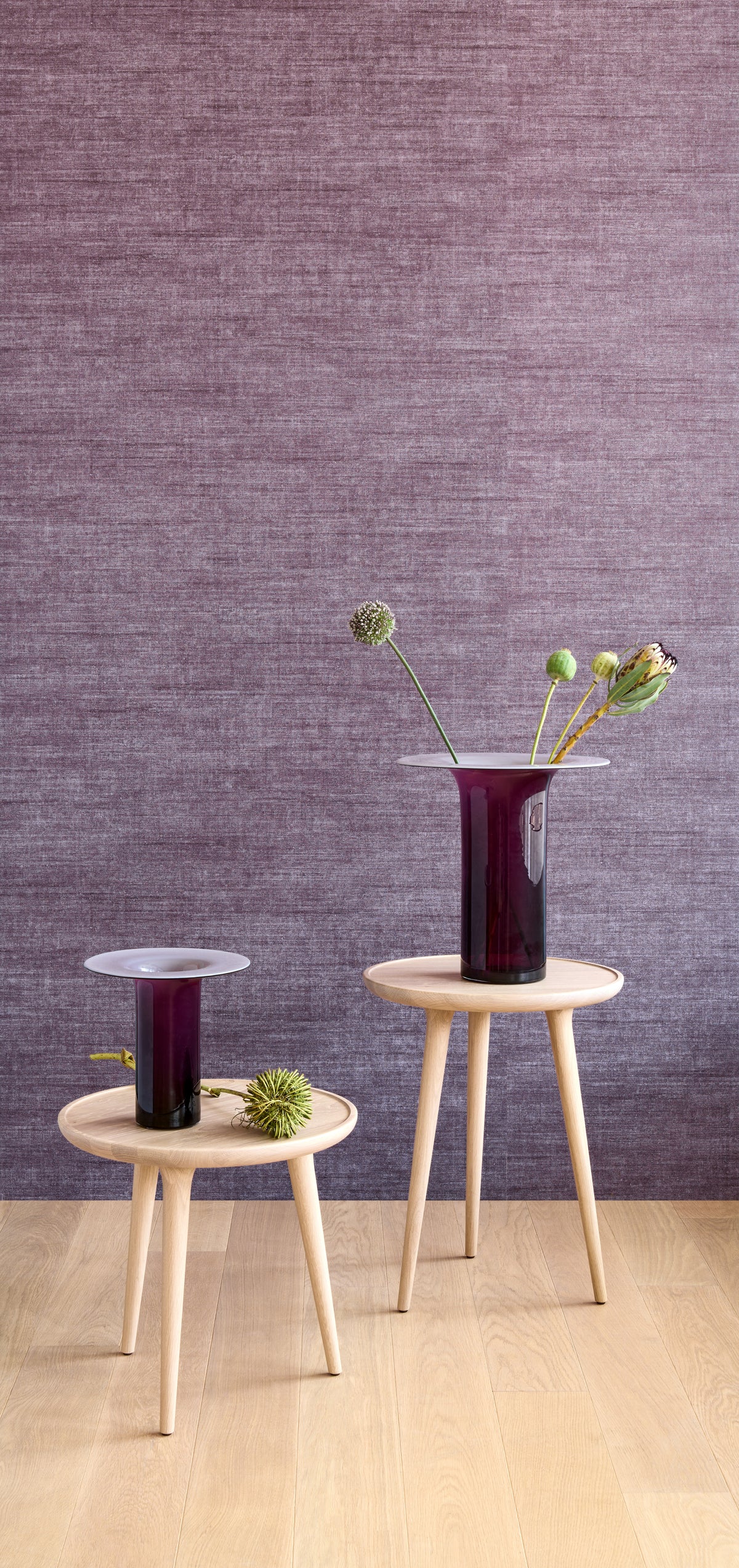 Canvas wallpaper by Arte in Purple behind two vases on small timber tables