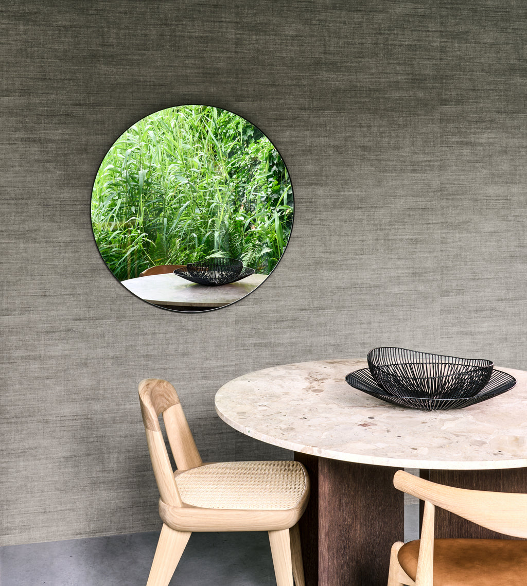 Canvas wallpaper by Arte in Grey – Urban behind a round dining table with a circular mirror