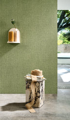 Nongo wallpaper by Arte in Green behind a plinth in a bright room