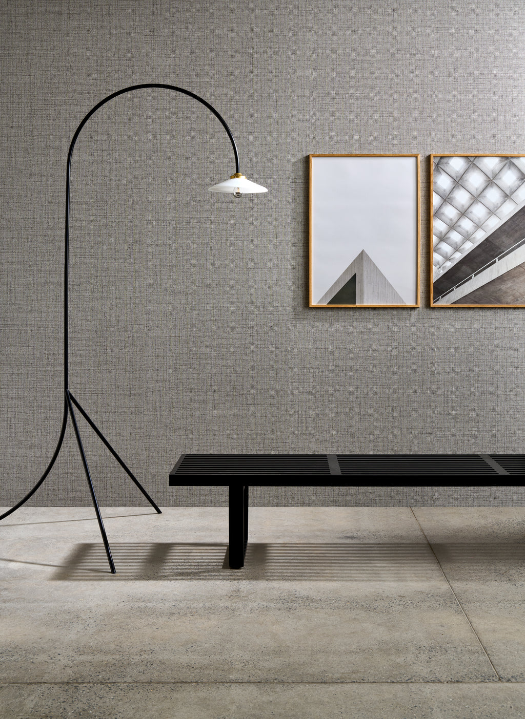 Puro wallpaper by Arte in Grey – Granite behind a bench, a floor lamp and framed prints