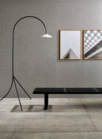 Puro wallpaper by Arte in Grey – Granite behind a bench, a floor lamp and framed prints