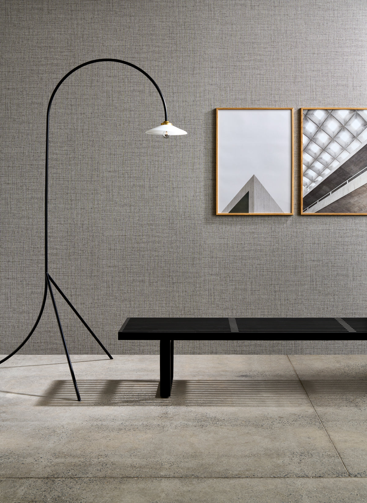 Puro wallpaper by Arte in Grey – Granite behind a bench, a floor lamp and framed prints