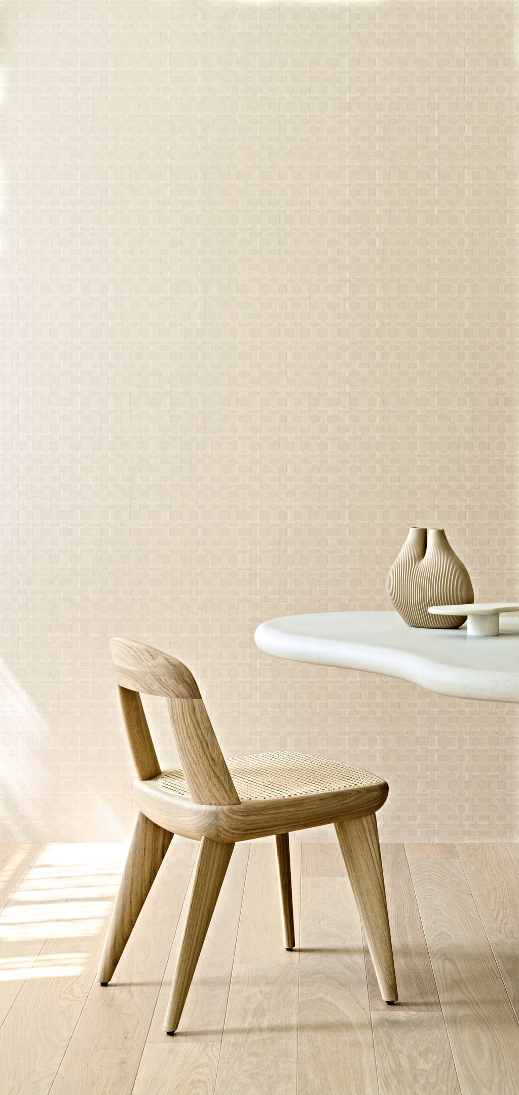 Weave wallpaper by Arte in Cream behind a timber chair and a small round table