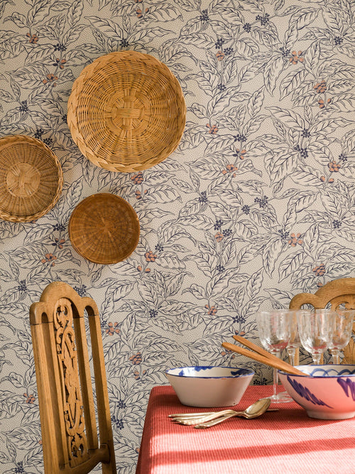 Caffeine wallpaper by Långelid/von Brömssen in Yellow - botanical design, behind woven wall discs and a laid table