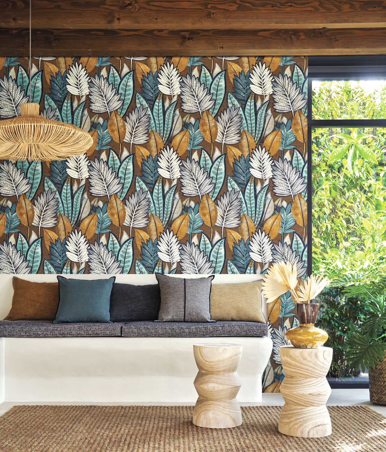 Sabal wallpaper by Casamance in tobacco and celadon, a palm leaf print styled behind a cushioned banquette by a garden window