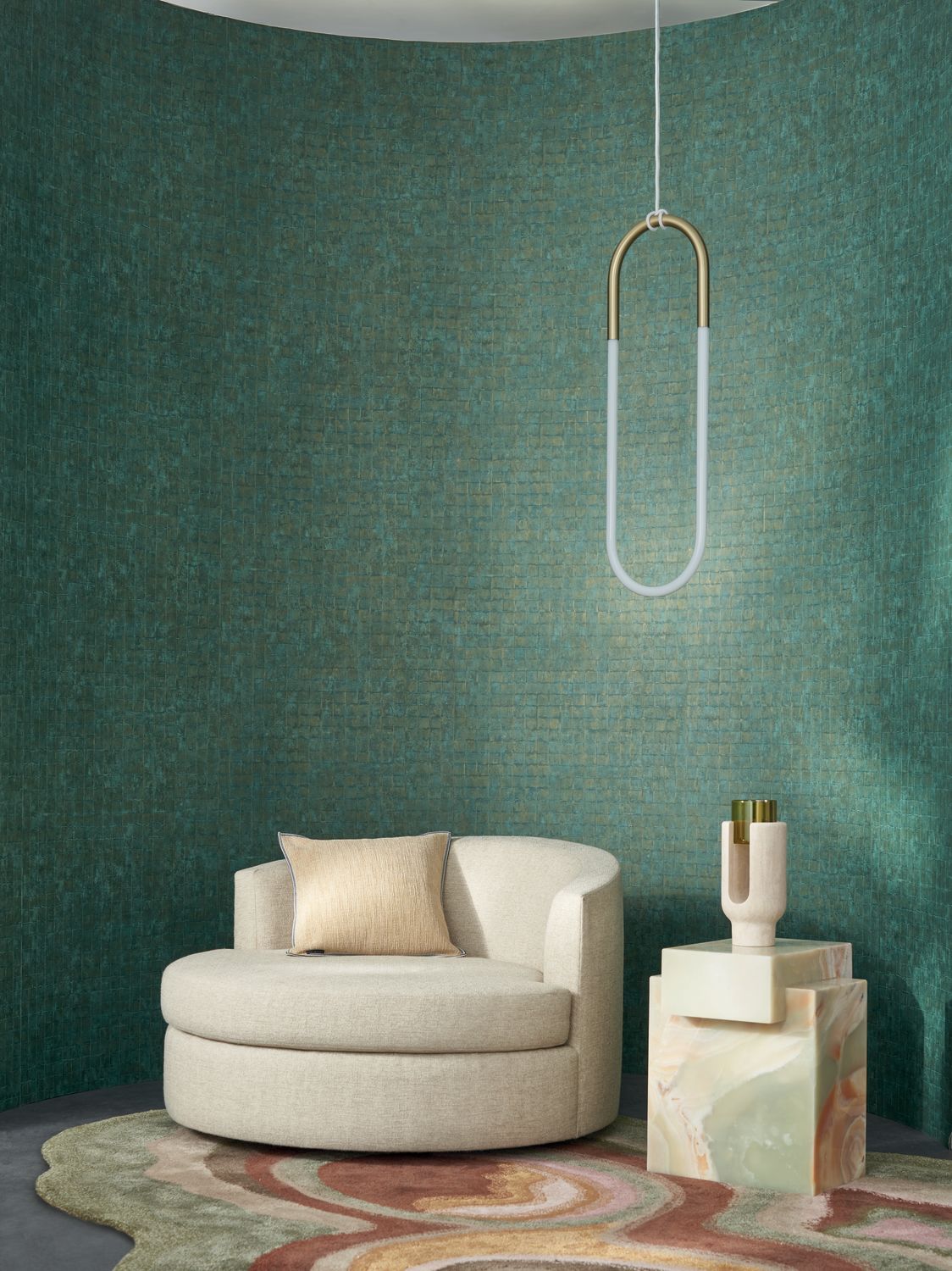 Faenza wallpaper by Casamance in emerald, a fine mosaic tile texture styled behind a cream swivel chair with a brass pendant