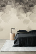 Bloom wallpaper by Emma Hayes in caramel, soft watercolour petals above a bed with charcoal bedding
