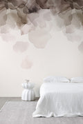 Bloom wallpaper by Emma Hayes in coffee brown, watercolour petals cascading above a white bed