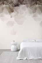 Bloom wallpaper by Emma Hayes in coffee brown, watercolour petals cascading above a white bed