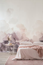 Bloom wallpaper by Emma Hayes in plum, watercolour petals rising up a wall above a blush-toned bed