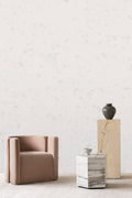 Breeze wallpaper by Emma Hayes in snow, delicate grey-flecked white wash behind a blush armchair and plinth
