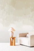 Canopy wall mural by Emma Hayes in Glint, gentle sage and cream watercolour wash in a styled living room with boucle sofa