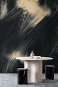 Celestial wall mural by Emma Hayes in Gold, dramatic black and gold sweeping brushstrokes behind a round stone dining table and stools