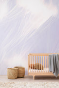 Celestial wall mural by Emma Hayes in Mauve, dreamy lavender feathered brushwork in a nursery with a wooden cot and woven