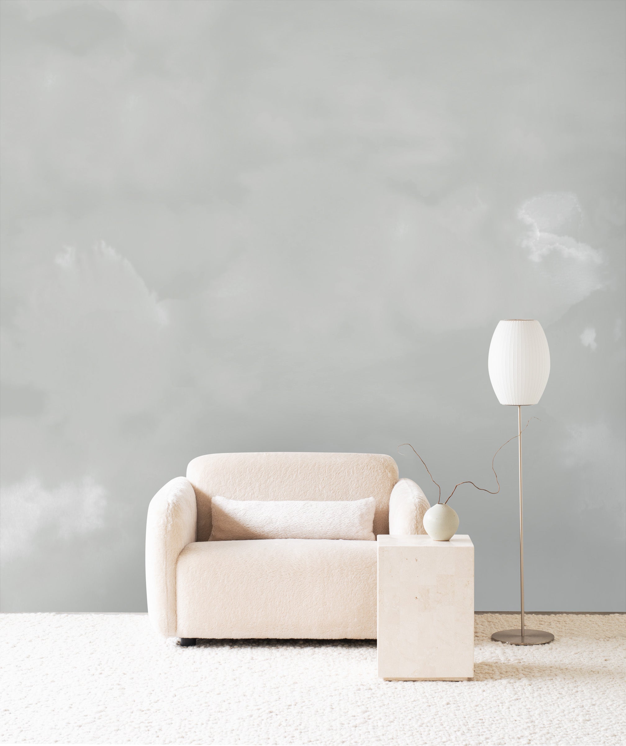 Dispersion wall mural by Emma Hayes in Mist, soft grey watercolour cloud forms behind a cream sofa