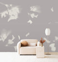 Drift wall mural by Emma Hayes in Dusk, cream foliage silhouettes on a soft mauve-grey ground behind a boucle sofa