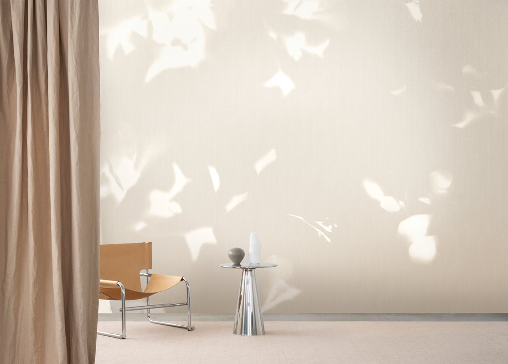 Drift wallpaper by Emma Hayes in Wheat, cyanotype foliage mural styled across a wide living-room wall — hero lifestyle shot