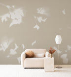 Drift wall mural by Emma Hayes in Wheat, soft white leaf silhouettes on a warm stone-beige ground