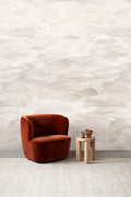 Dune wall mural by Emma Hayes in Buff, soft cream and pale beige watercolour dunes behind a rust velvet armchair