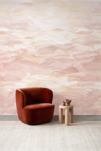 Dune wallpaper by Emma Hayes in soft blush pink watercolour dunes styled behind a rust velvet armchair and wooden side table