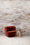 Dune wall mural by Emma Hayes in Plum, warm grey-taupe watercolour dune layers behind a rust velvet armchair