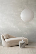 Nebula wall mural by Emma Hayes in Ivory, soft off-white misty clouds behind a cream chaise and paper lantern