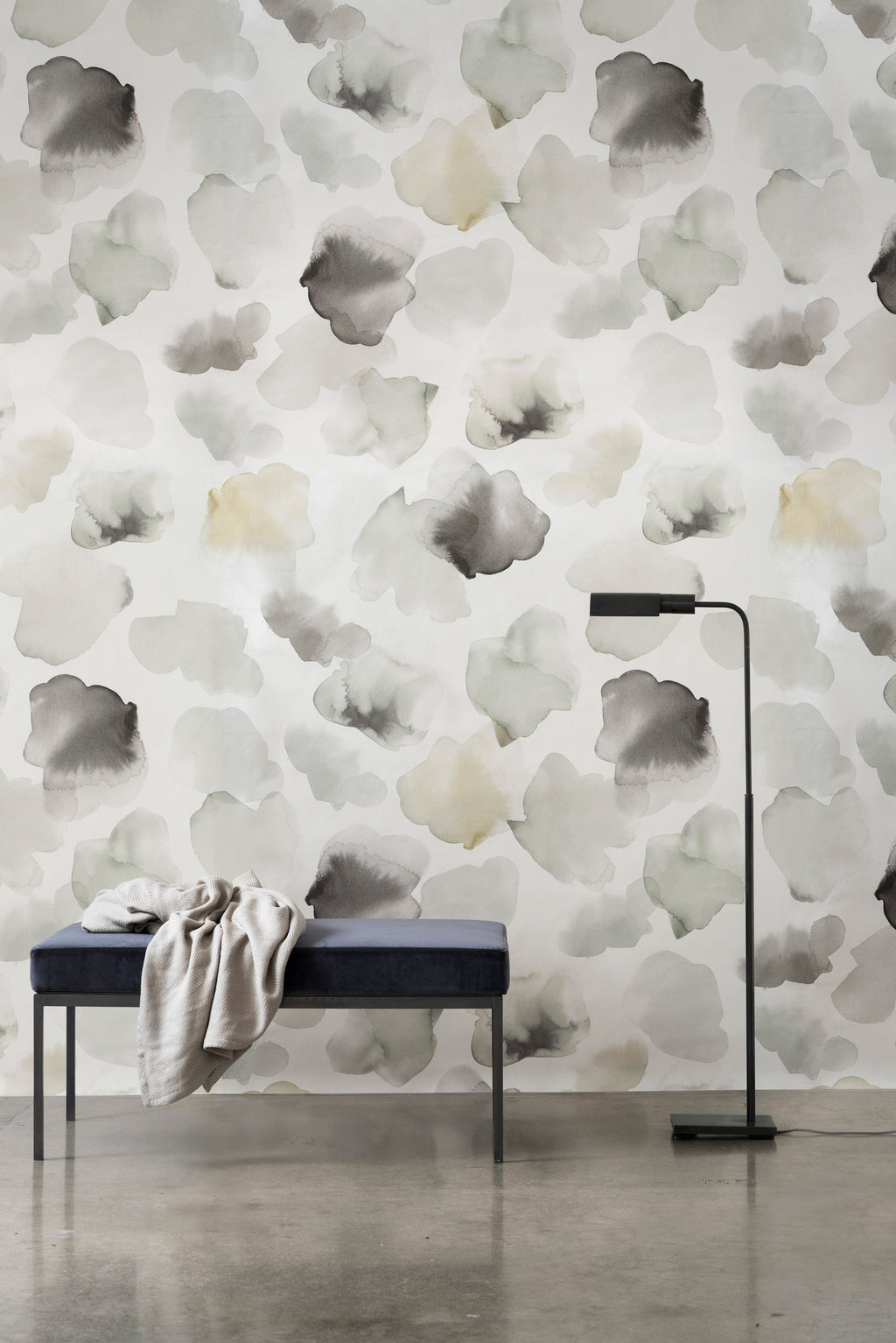 Petals Pressed wallpaper by Emma Hayes in sage and grey, muted watercolour petals on white, styled above a velvet bench and floor lamp