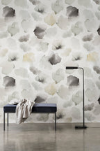 Petals Pressed wallpaper by Emma Hayes in sage and grey, muted watercolour petals on white, styled above a velvet bench and floor lamp