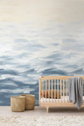 Seascape wall mural by Emma Hayes in Turquoise, blue and white wave-like brushstrokes styled in a nursery above a
