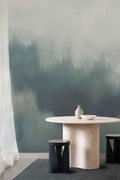 Solar wall mural by Emma Hayes in Emerald, misty deep green abstract haze styled behind a pale stone dining table and dark stools