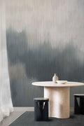 Solar wall mural by Emma Hayes in Gunmetal Metallic, smoky grey haze with a shimmering metallic finish behind a pale stone dining table and black stools