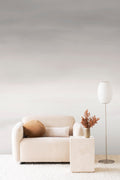 Stratum ombre wall mural by Emma Hayes in ashen grey-mauve tones, styled in a living room behind a cream boucle sofa