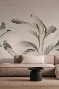 Swirl wall mural by Emma Hayes in coffee and sage-green brushstroke foliage, styled in a living room above a taupe sofa