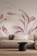 Swirl wall mural by Emma Hayes, painterly plum and blush-pink brushstroke leaves, styled behind a taupe living-room sofa