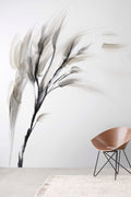 Willow wall mural by Emma Hayes in charcoal and grey ink-wash grasses on white, styled beside a timber chair and woven rug