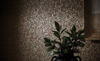 Dufrene wallpaper by Romo, a mottled distressed plaster effect in greige, styled with a gilt frame and dark foliage
