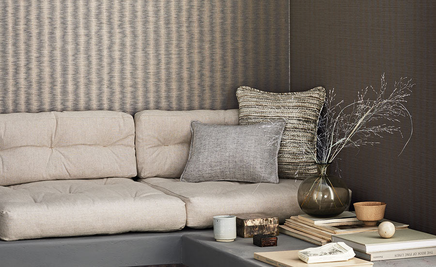 Kutai wallpaper by Romo, a soft painterly ikat stripe in stone and grey, styled behind a cream linen sofa