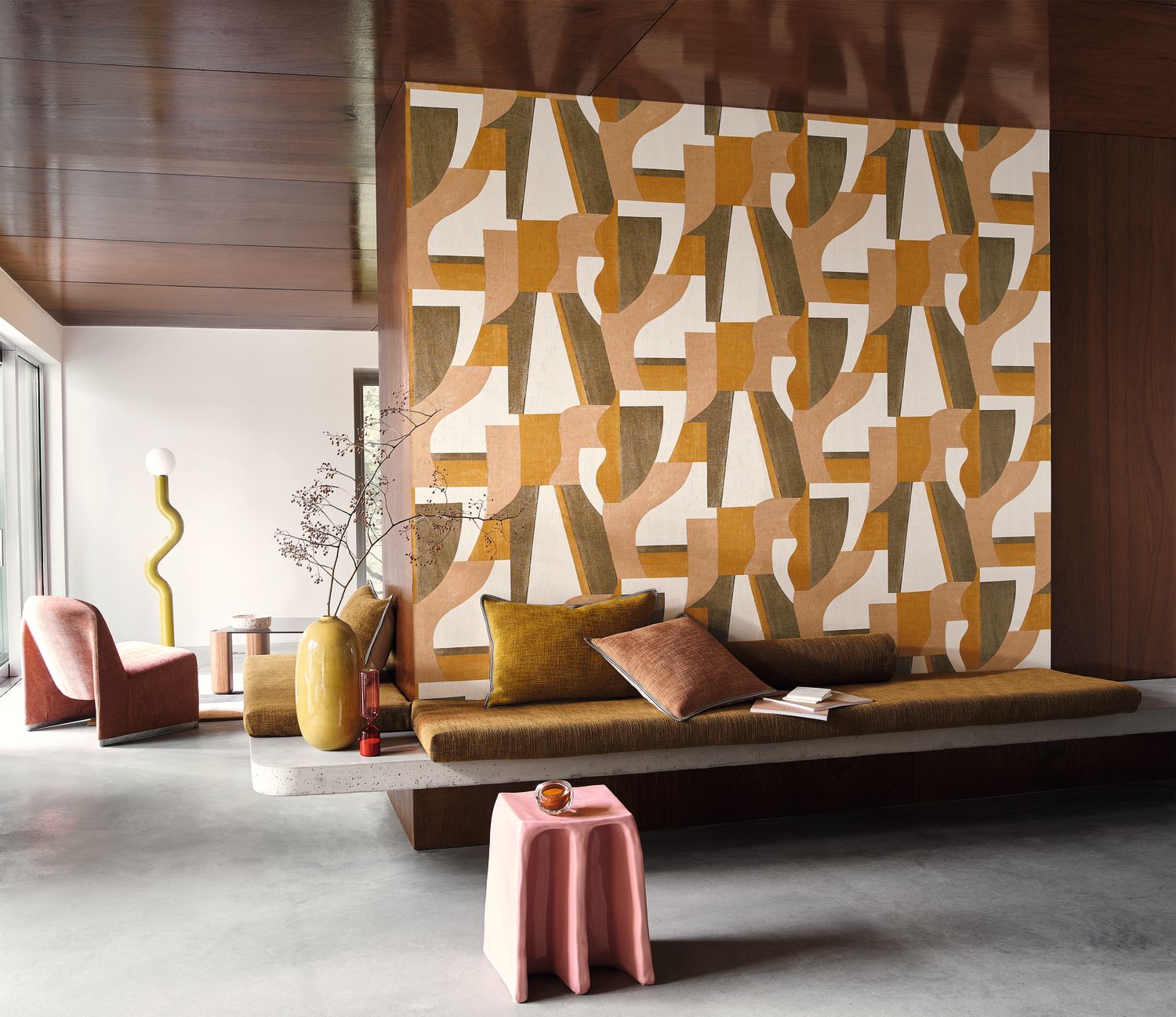 Gino wallpaper by Casamance in ochre and cream, bold abstract shapes styled on a panel above a low daybed