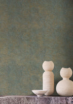 Lore wallpaper by Casamance in teal and gold, a feathered metallic texture styled behind pale sculptural vases