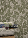 Olive green Oak Tree Tails wallpaper by Emma von Brömssen with squirrels and oak leaves, beside rolled wallpaper samples
