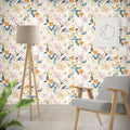 Sunshine Floral wallpaper by Cass Deller styled in a living room behind a tripod floor lamp and grey armchair