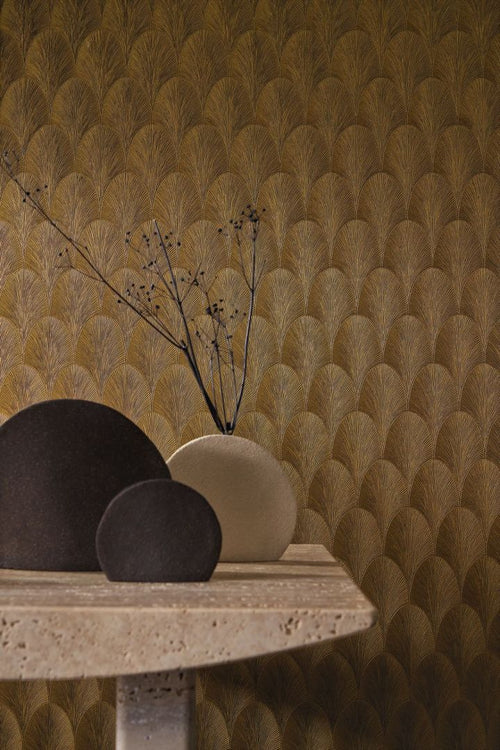Tourmaline Gold wallpaper by Casamance styled behind a travertine table with sculptural vases, golden Art Deco fan motif
